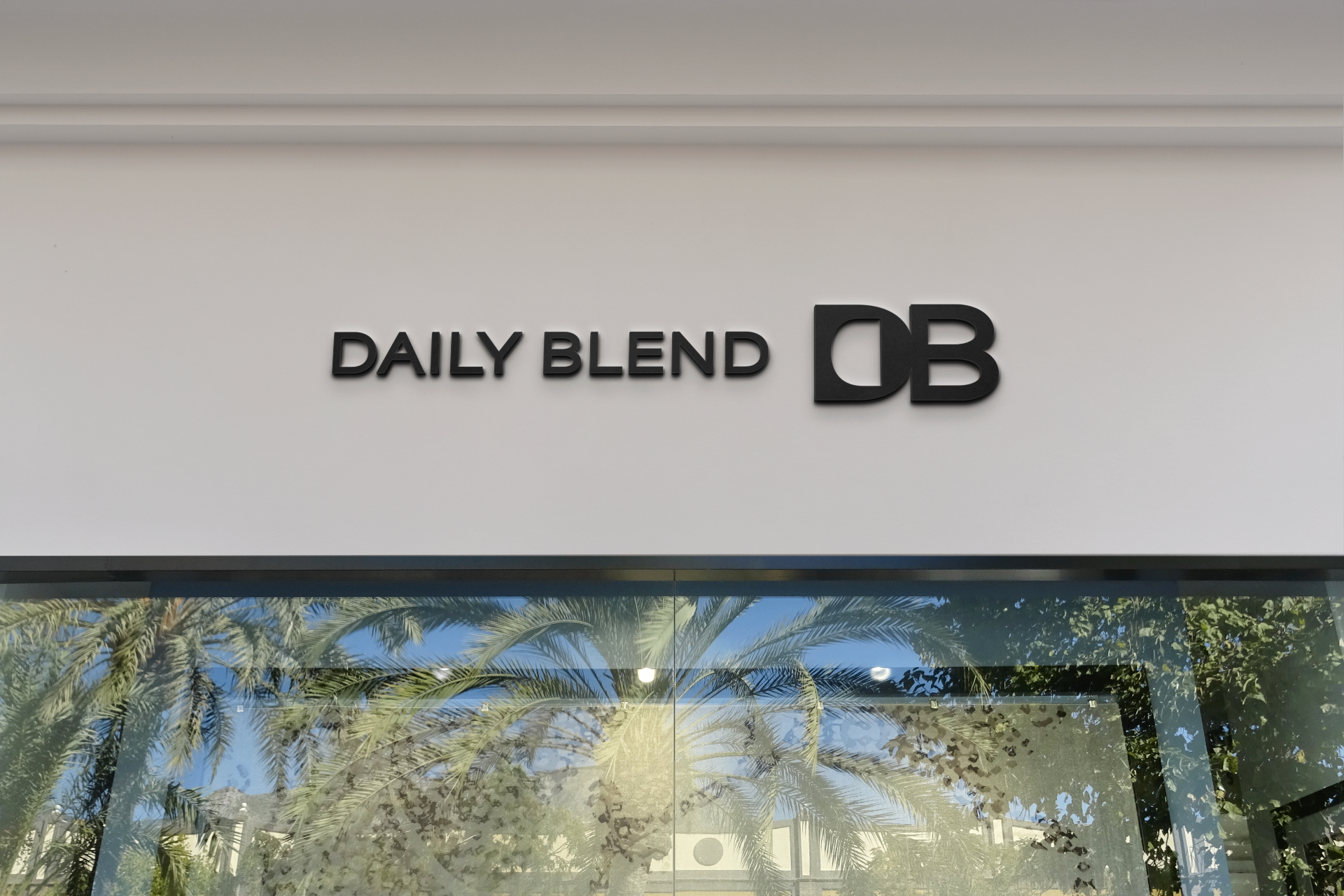 Daily Blend storefront signage with DB monogram on a white wall